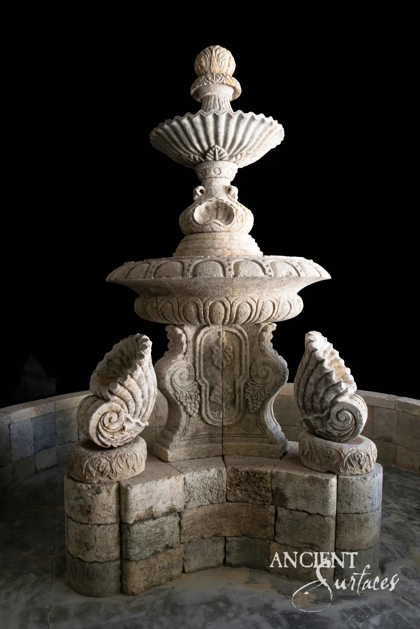 Ornate two-tier limestone pool fountain with gadrooned bowls, pineapple finial and shell spouts