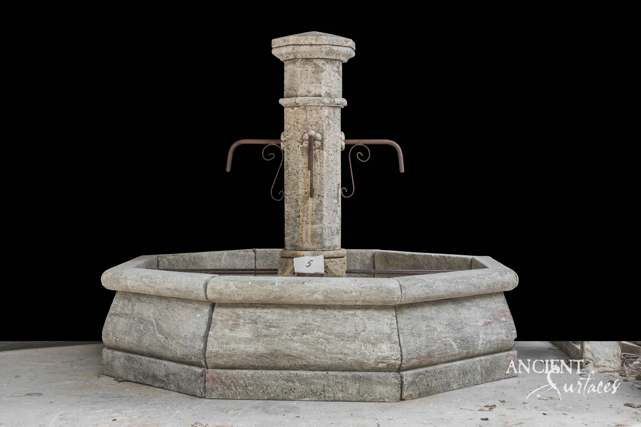 Hand-carved antique limestone pillar fountain with an octagonal basin showing natural patina